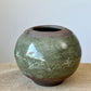 Wheel thrown stoneware clay. A band of green covers the belly of the dark brown clay. Hand carved.